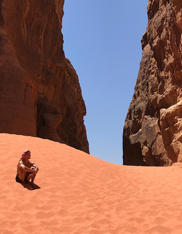 Man sitting on sand in desert