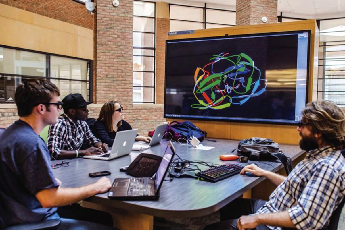 a photo of one of the VizHubs on the 2nd Floor mezzanine. These are comfortable collaborative workstations with the ability to render complex data sets on a large shared 4K screen.