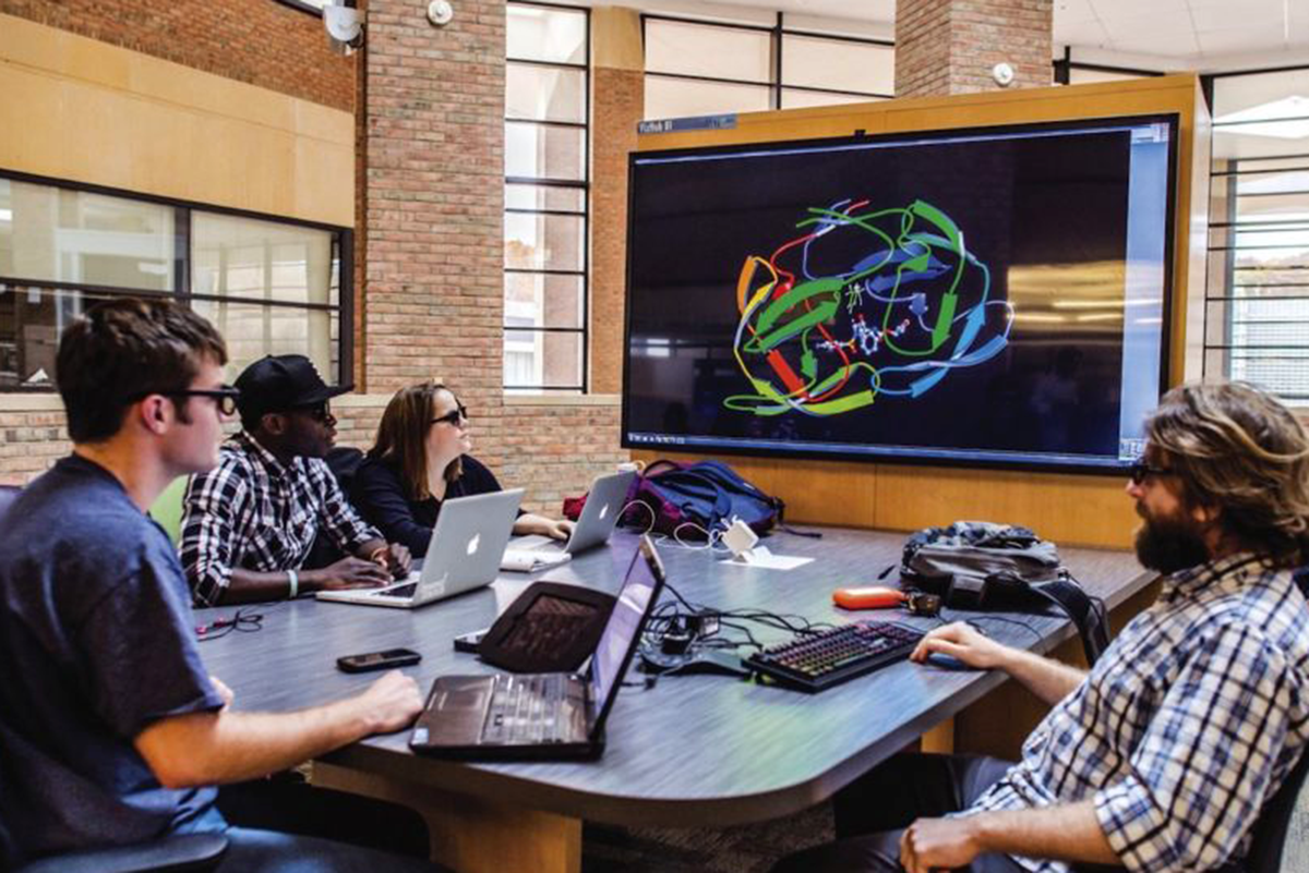 a photo of one of the VizHubs on the 2nd Floor mezzanine. These are comfortable collaborative workstations with the ability to render complex data sets on a large shared 4K screen. 