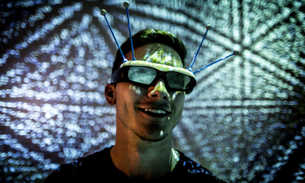 view of an Engineering Student using headset for stereo viewing inside the MiDen 3D Visualization space