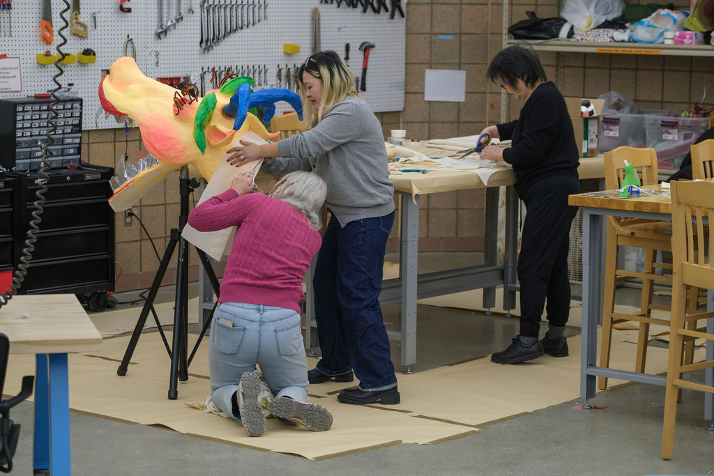 Students wotking on Dragon construction with artist Zhen Guo