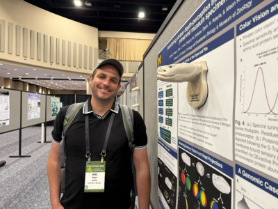 Mike Hogan poses with his poster and a 3D printed snake, an Eastern diamondback rattlesnake, at a conference.