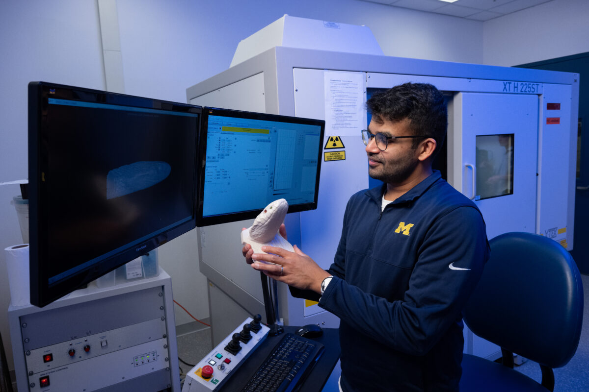 Ramon Nageson holds a 3D printed snake in UMMZ's lab