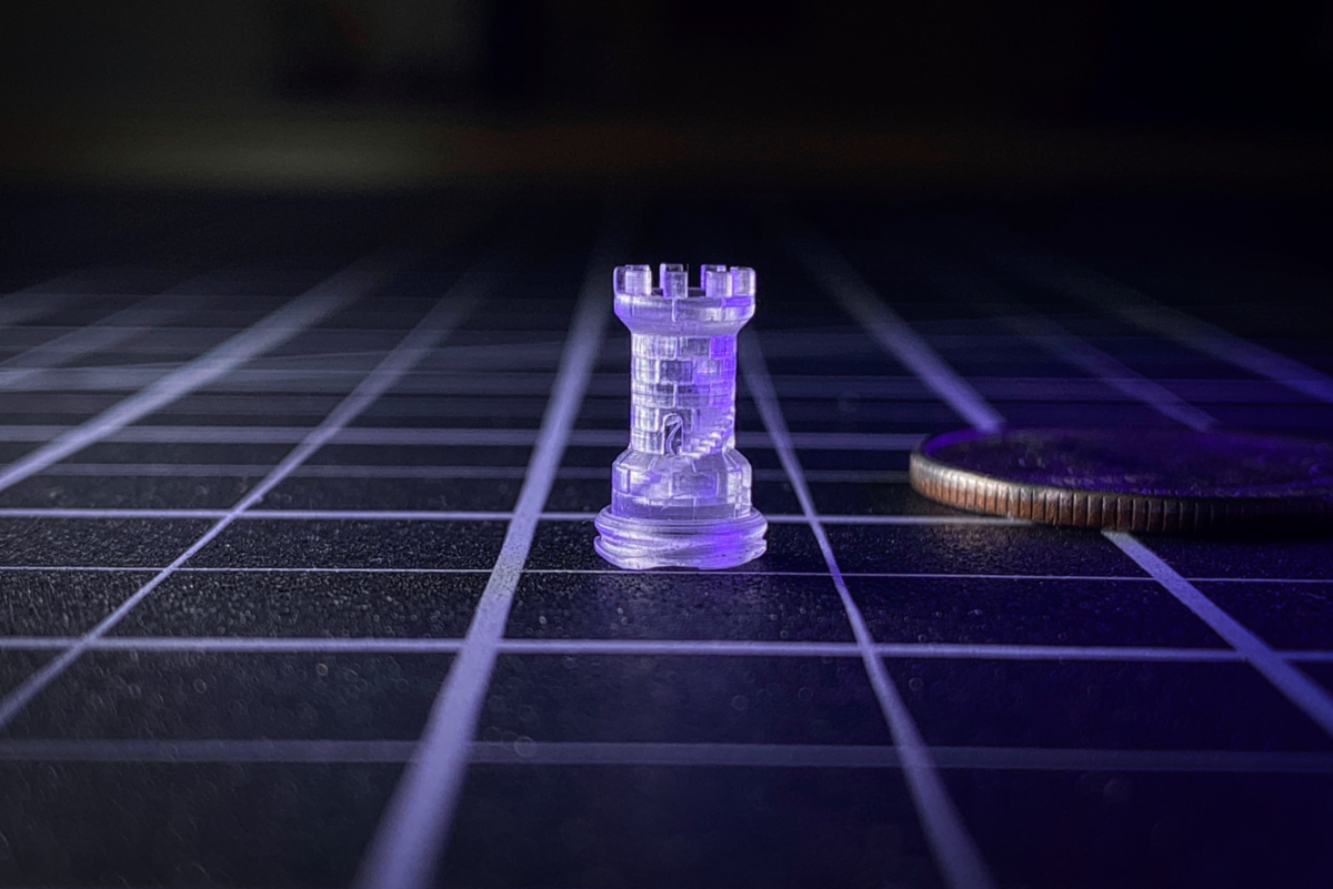 image: a miniature castle tower, complete with an interior staircase, less than 1" tall, printed in 3D on the Asiga Max X 3D printer (a U.S. Quarter coin shown for scale)