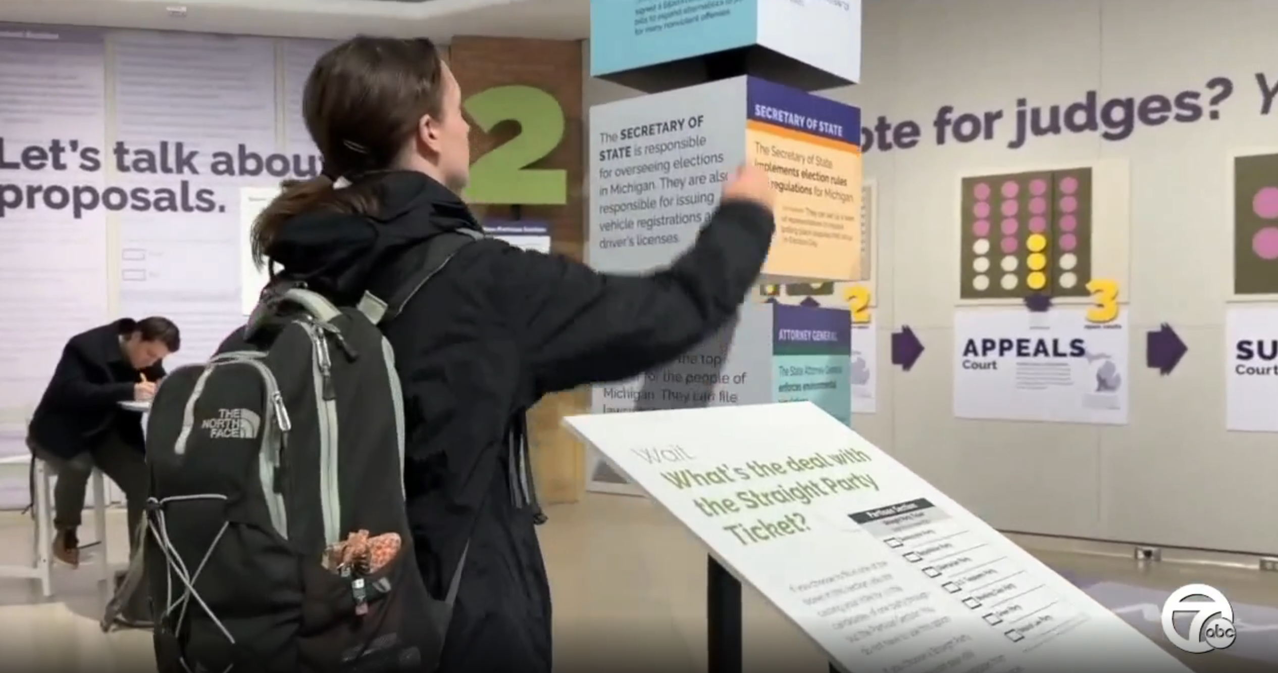 image of a student reading an exhibit in the immersive "Ballot Wayfinder" - part of the Vote 2022 Campus Creative Voting Project installation in the DC Gallery