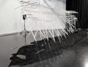 Photo of "Eel" art piece. White frame with tulle and thread arms.