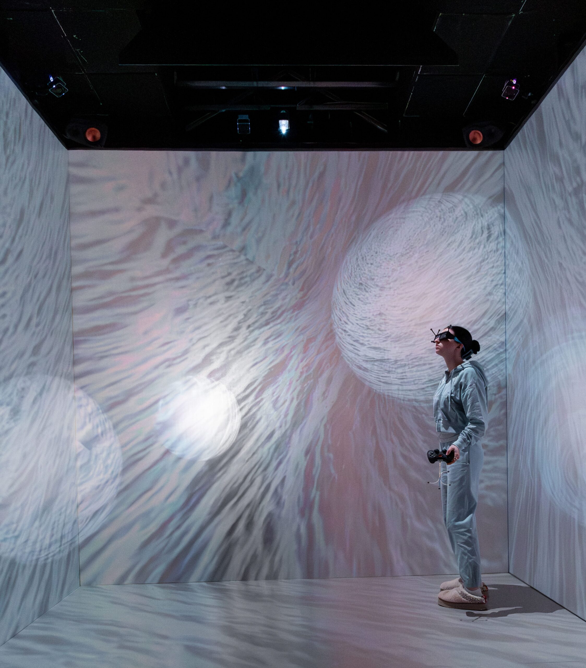 A girl with VR glasses and controller in a space featuring 3D motion.