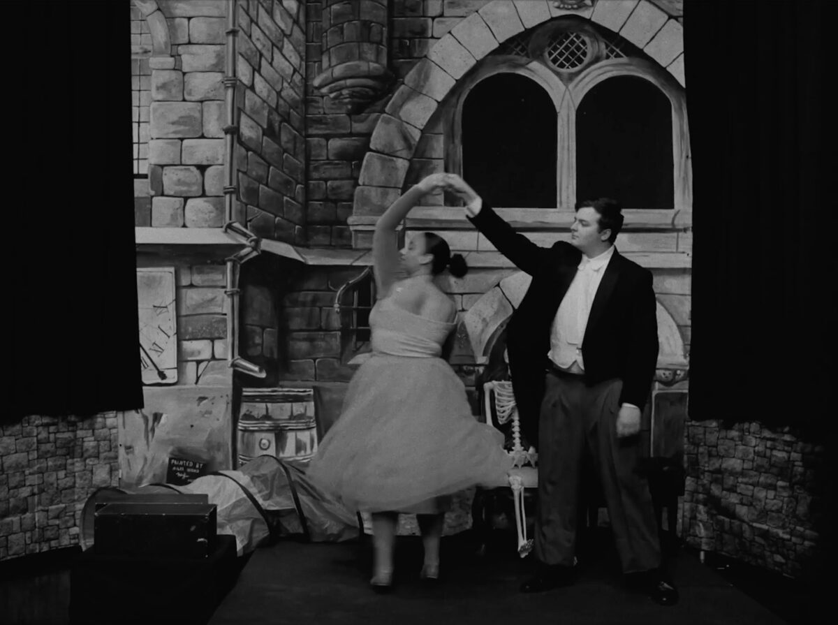 A couple dancing in front of the black and white background