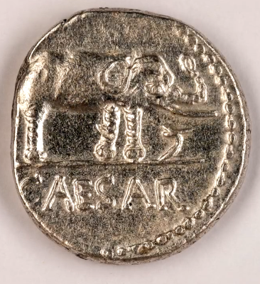 Back side of an ancient coin featuring the word "Caesar"